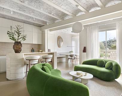 Salón del proyecto Córsega de ÀBAG Studio en el Eixample de Barcelona, con sofás Julep de Tacchini en verde y bóvedas catalanas vistas