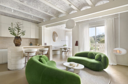 Salón del proyecto Córsega de ÀBAG Studio en el Eixample de Barcelona, con sofás Julep de Tacchini en verde y bóvedas catalanas vistas