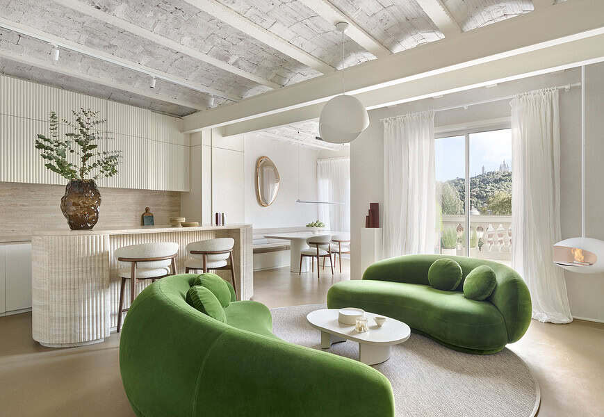 Salón del proyecto Córsega de ÀBAG Studio en el Eixample de Barcelona, con sofás Julep de Tacchini en verde y bóvedas catalanas vistas
