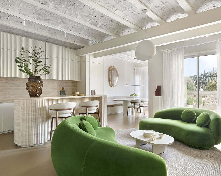Salón del proyecto Córsega de ÀBAG Studio en el Eixample de Barcelona, con sofás Julep de Tacchini en verde y bóvedas catalanas vistas