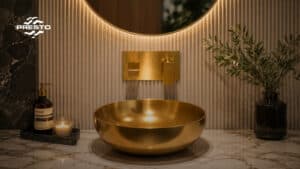 Lavabo de sobremesa dorado con grifería empotrada Presto Ibérica Nitro Plus acabado gold brushed en baño de diseño con mármol y pared de lamas verticales