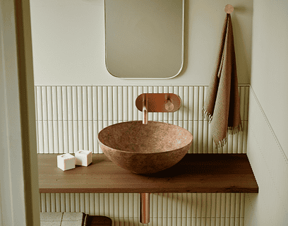 Lavabo Bathco New Lys con acabado Tierra de tonos cálidos y orgánicos sobre encimera de madera en baño de estilo natural