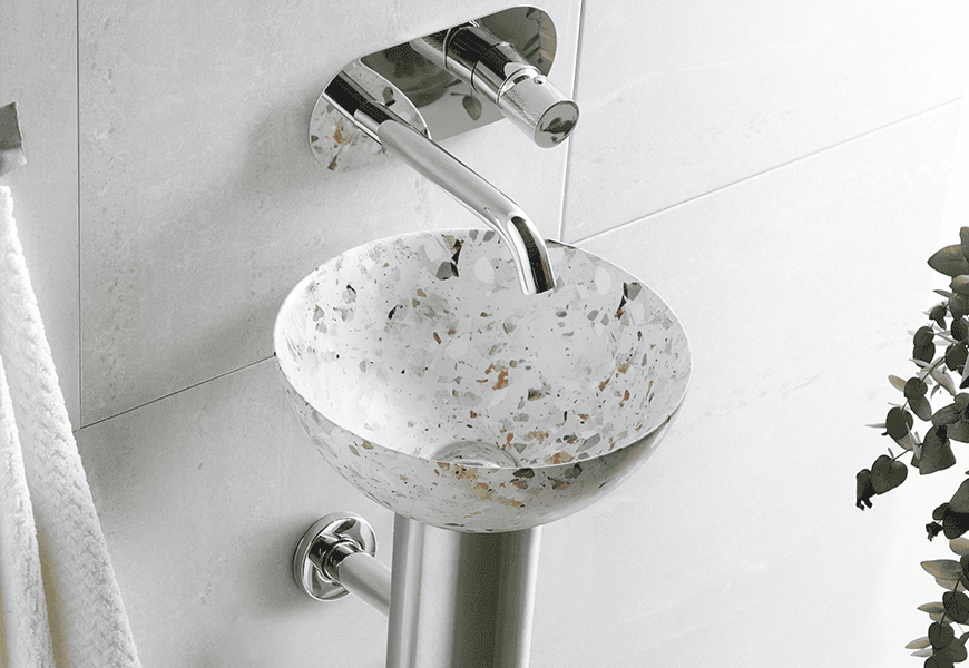 Lavabo Bathco Dakar con acabado Terrazo Terranova sobre pedestal de acero inoxidable en baño blanco minimalista