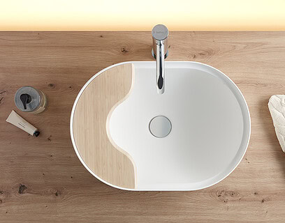 Lavabo oval Seceda de Bathco en Solid Surface blanco sobre encimera de madera con bandeja integrada de bambú