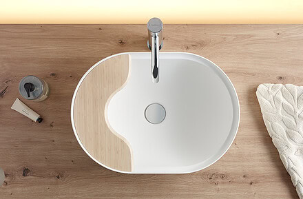 Lavabo oval Seceda de Bathco en Solid Surface blanco sobre encimera de madera con bandeja integrada de bambú