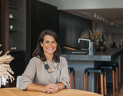 Natalia Zubizarreta, interiorista del estudio Natalia Zubizarreta Interiorismo de Bilbao, en espacio de cocina con mobiliario oscuro y materiales naturales