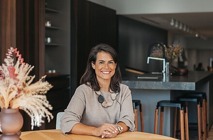 Natalia Zubizarreta, interiorista del estudio Natalia Zubizarreta Interiorismo de Bilbao, en espacio de cocina con mobiliario oscuro y materiales naturales