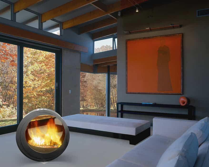 (chimenea Eclypsya en salón) Chimenea de leña nómada Arkiane modelo Eclypsya de diseño circular en salón contemporáneo con vistas al jardín otoñal