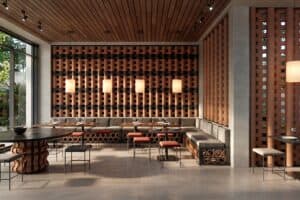 Interior de restaurante con sistema modular cerámico O-Buit de Gresmanc Group, con piezas extrusionadas en terracota formando composición tridimensional en pared de fondo