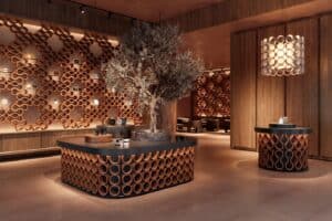 Recepción de hotel con celosías y mostrador en sistema cerámico O-Buit de Gresmanc Group, con juego de luces y sombras sobre suelo neutro