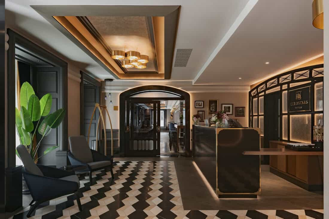Recepción del hotel Eurostars Lisboa Baixa diseñada por PF1 Interiorismo Contract, con suelo ajedrezado, latón dorado y estética inspirada en el tranvía lisboeta