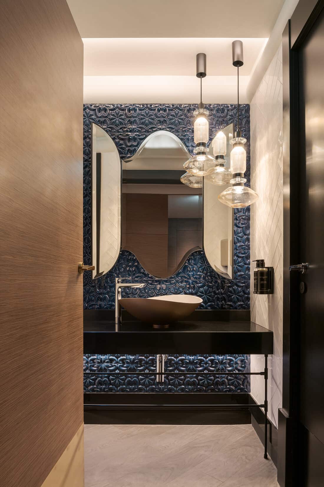 Baño del hotel Eurostars Lisboa Baixa diseñado por PF1 Interiorismo Contract, con azulejos portugueses azules pintados a mano y lámparas de cristal artesanal