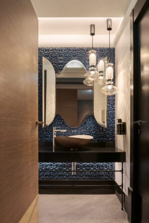 Baño del hotel Eurostars Lisboa Baixa diseñado por PF1 Interiorismo Contract, con azulejos portugueses azules pintados a mano y lámparas de cristal artesanal