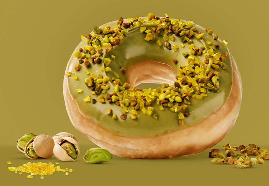 Donut Master Pistacho de Krispy Kreme con glaseado verde de pistacho y granillo de pistacho tostado Borges sobre fondo verde