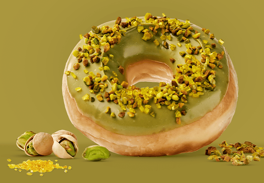 Donut Master Pistacho de Krispy Kreme con glaseado verde de pistacho y granillo de pistacho tostado Borges sobre fondo verde